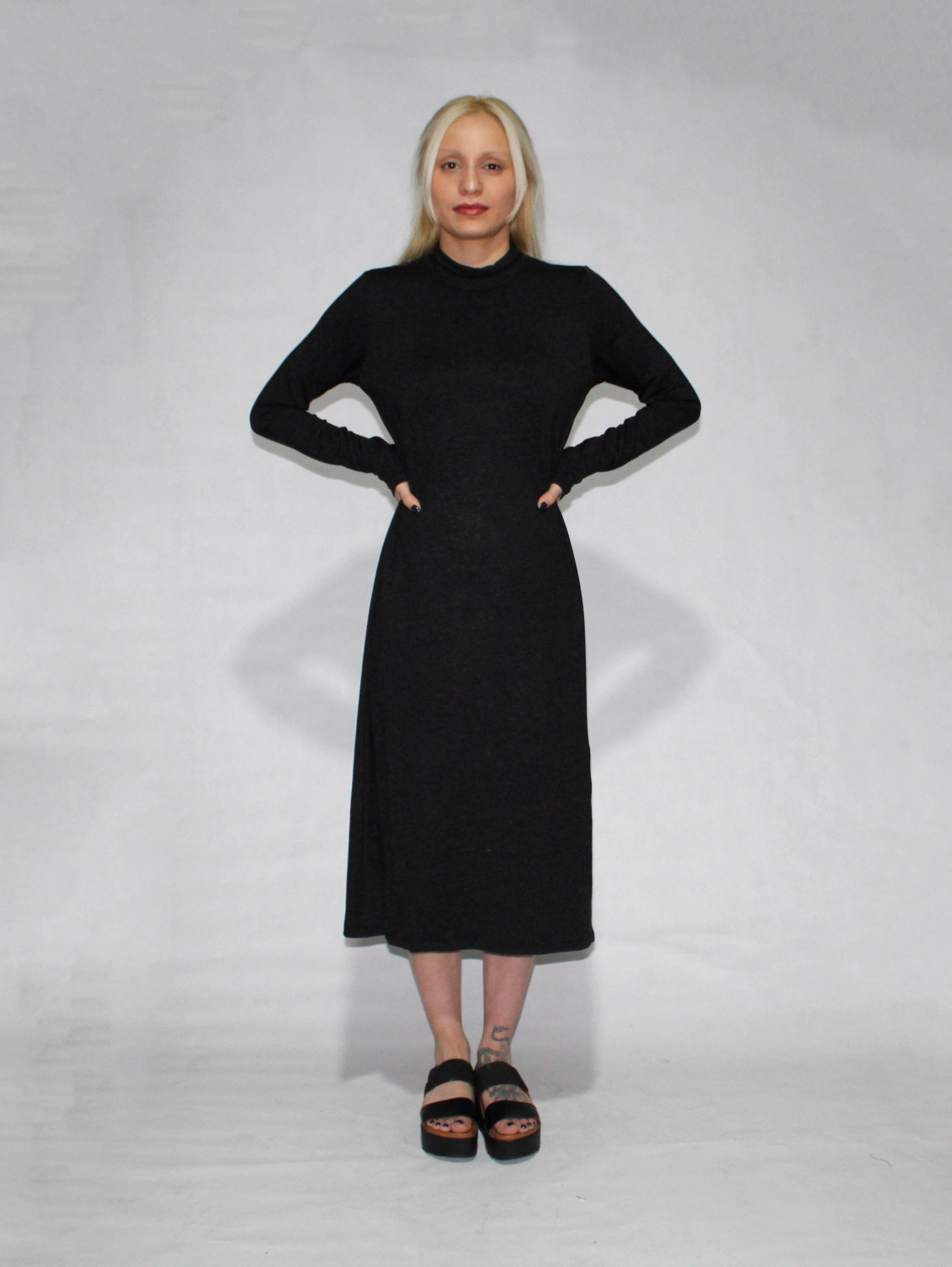 Vestido negro manga larga cuello alto con aberturas laterales